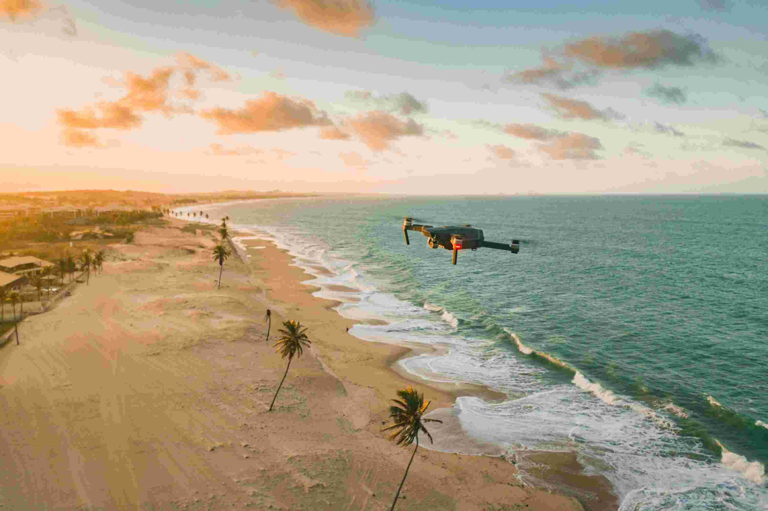 drone voando sobre o mar e a praia 