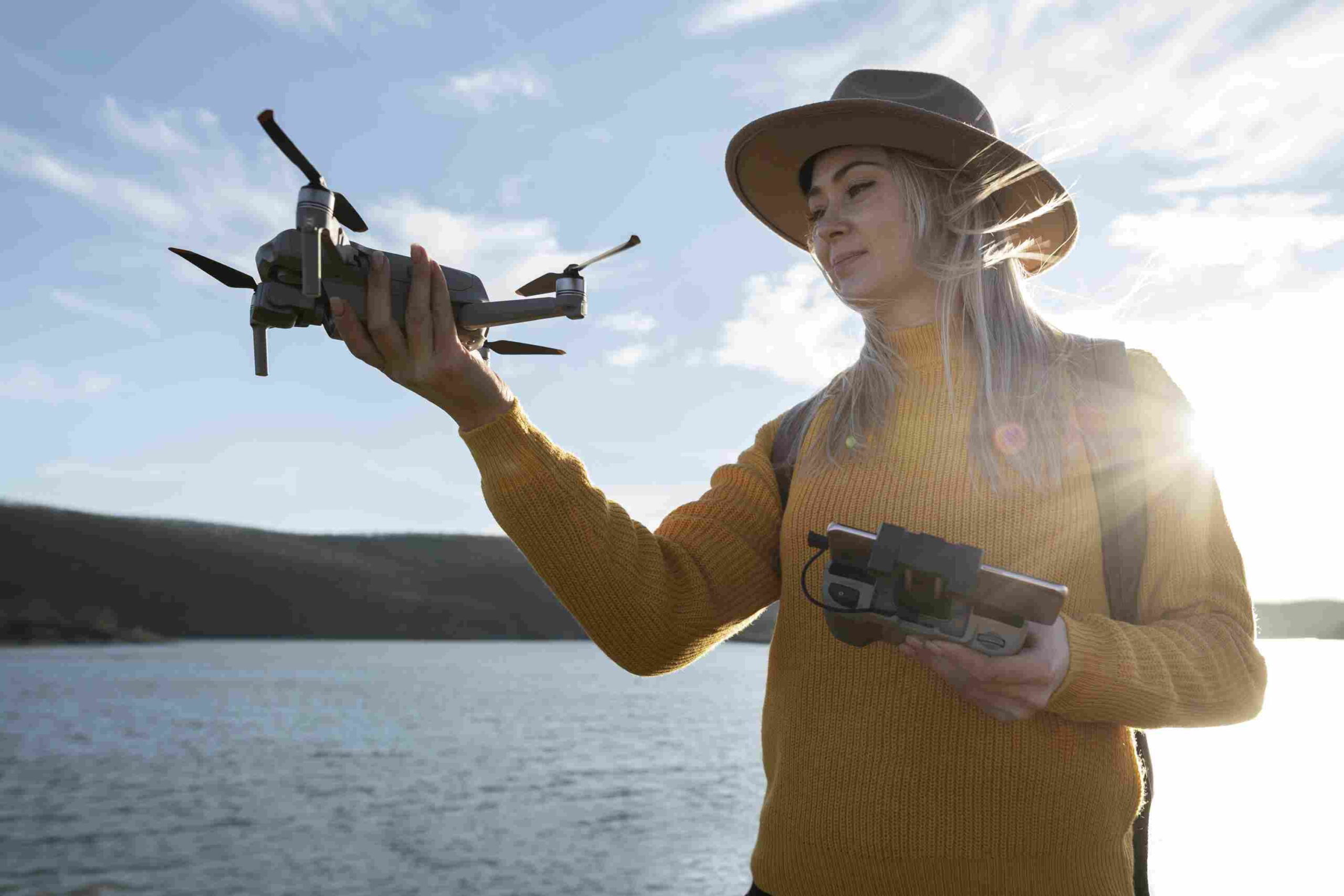 mulher segurando drone e controle remoto 