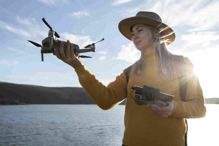 mulher segurando drone e controle remoto