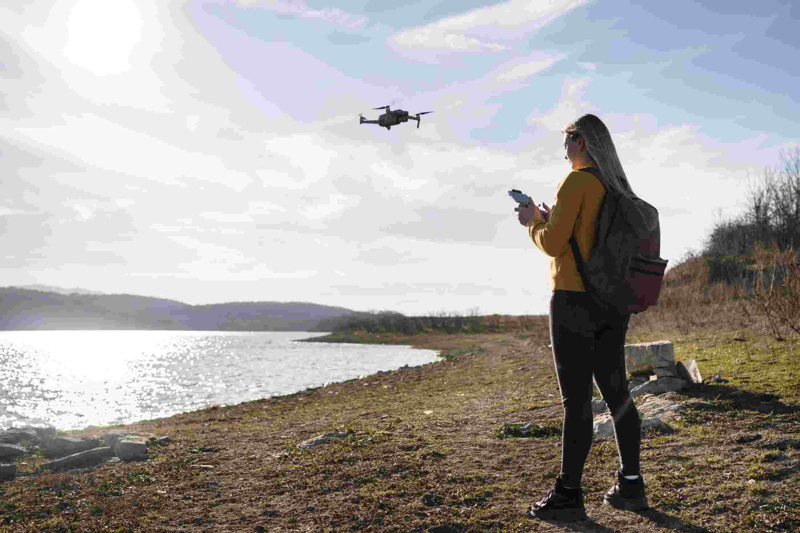 mulher voando com drone ao ar livre baixa altitude 